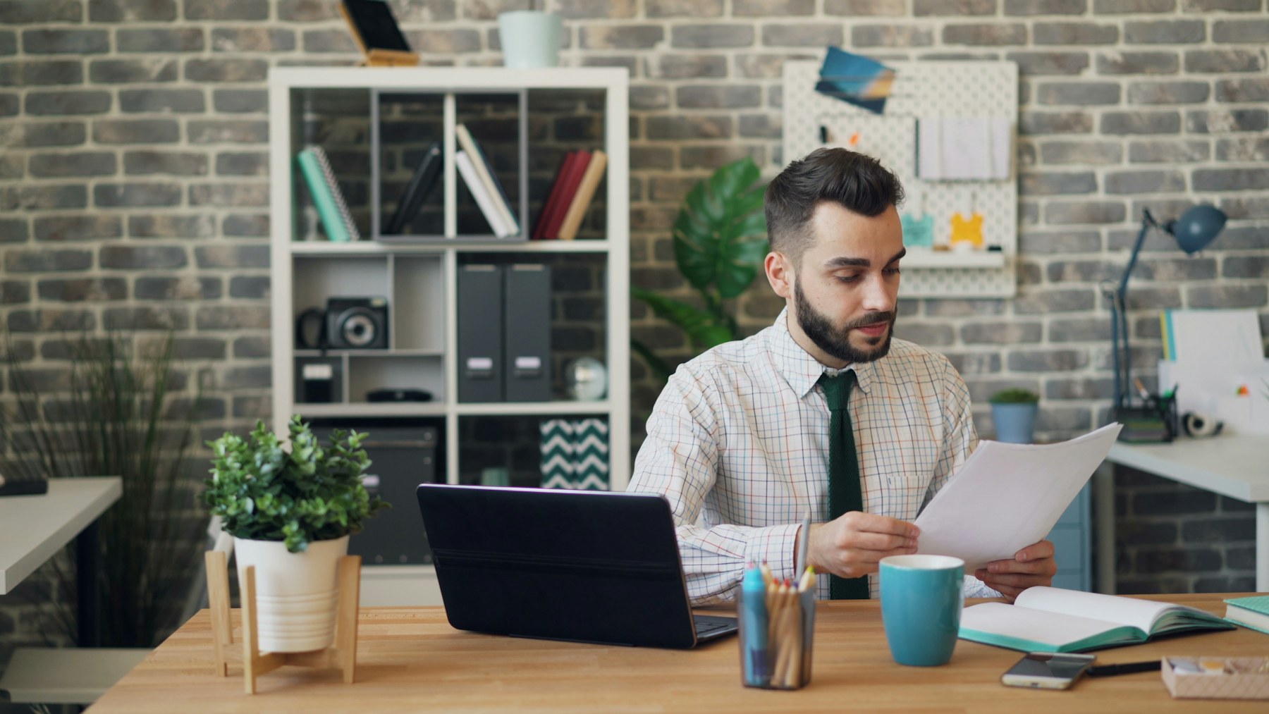 Mitarbeiter prüft Vertragsunterlagen am Arbeitsplatz